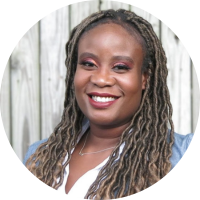 Black woman with long locked hair, smiling broadly